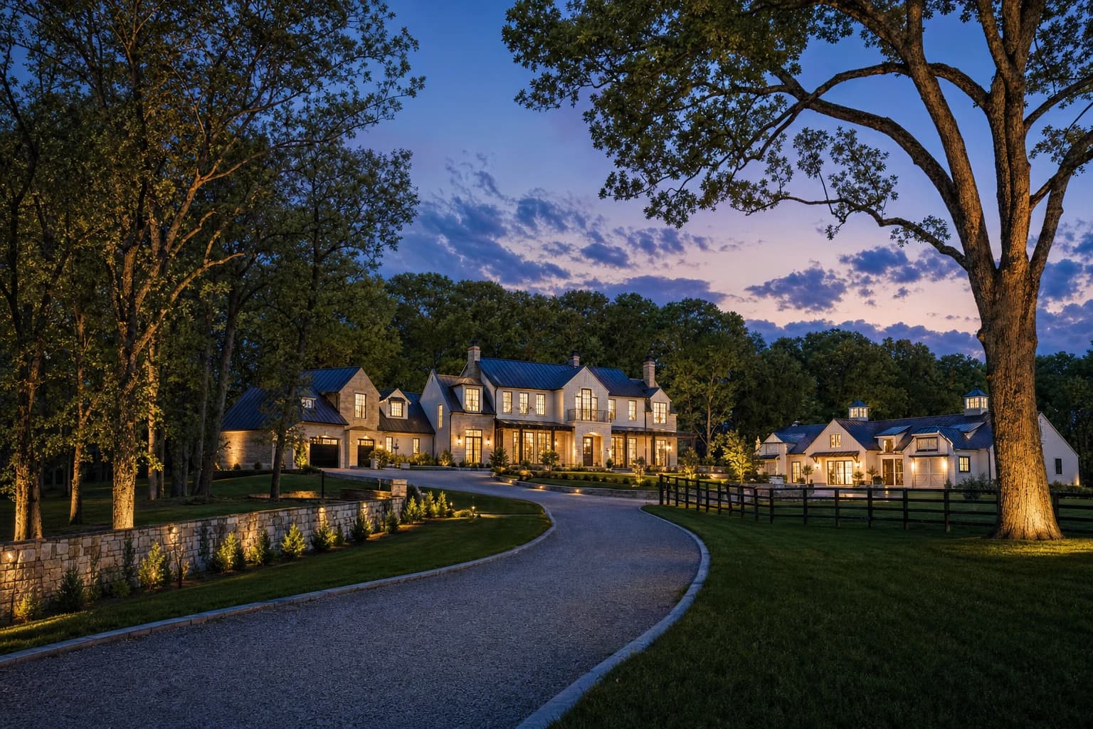 A breathtaking twilight shot of a sprawling, ultra-luxury modern farmhouse and equestrian estate sitting on 5 heavily wooded acres in Clifton, Virginia